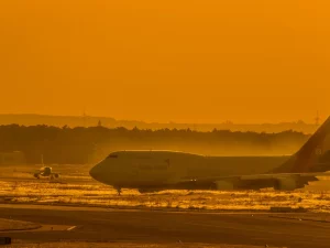 Pesawat Boeing 747 di landasan bandara saat matahari terbenam