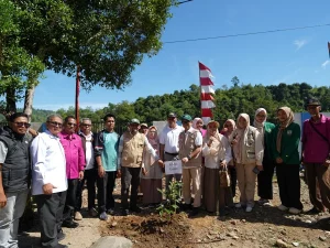 Rombongan sivitas akademika dan warga berfoto di lokasi penanaman bibit pohon di kaki bukit