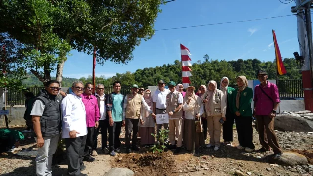 Rombongan sivitas akademika dan warga berfoto di lokasi penanaman bibit pohon di kaki bukit