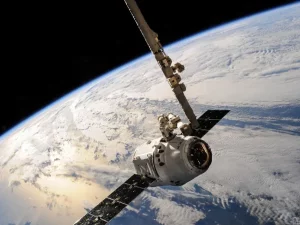 Sebuah satelit mengorbit dengan latar permukaan Bumi