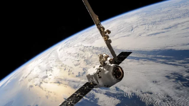 Sebuah satelit mengorbit dengan latar permukaan Bumi