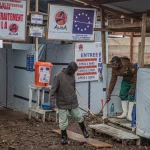 Petugas mendisinfeksi kaki pengunjung di Pusat Pengobatan Ebola Rwampara, Bunia, Ituri, RD Kongo