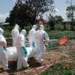 Petugas berpakaian pelindung lengkap mengangkat jenazah korban Ebola di Republik Demokratik Kongo.