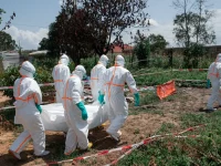 Petugas berpakaian pelindung lengkap mengangkat jenazah korban Ebola di Republik Demokratik Kongo.