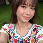 Yuki Kato berswafoto dengan gaya poni terbaru mengenakan atasan bordir bunga di taman