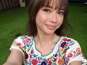 Yuki Kato berswafoto dengan gaya poni terbaru mengenakan atasan bordir bunga di taman