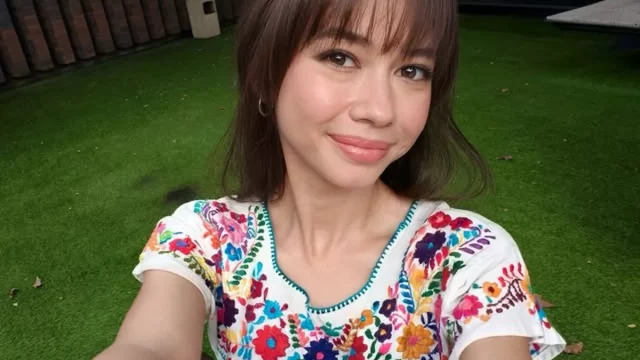 Yuki Kato berswafoto dengan gaya poni terbaru mengenakan atasan bordir bunga di taman
