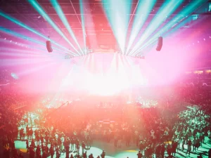 Ilustrasi suasana konser musik dengan lampu panggung warna-warni di arena, bukan foto konser Zico yang sebenarnya