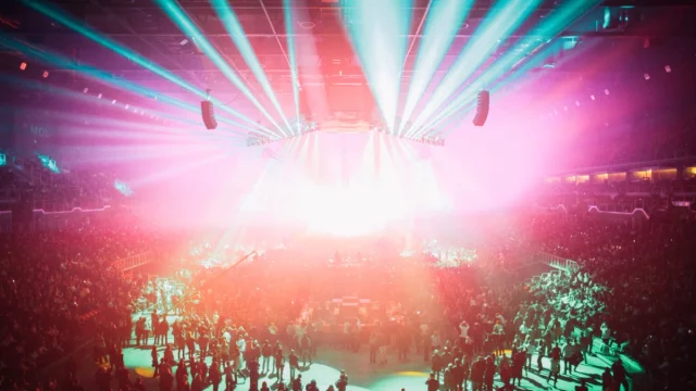 Ilustrasi suasana konser musik dengan lampu panggung warna-warni di arena, bukan foto konser Zico yang sebenarnya