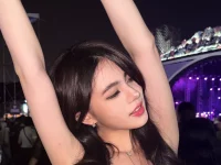 Zoe Levana mengangkat kedua tangan di area penonton LaLaLa Fest dengan panggung berlampu ungu di belakangnya.