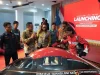 Sejumlah orang mengelilingi mobil hemat energi berwarna hitam dan merah di dalam ruangan berlatar layar bertuliskan Launching.