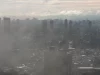 Permukiman padat sebuah kota tertutup kabut asap tebal dilihat dari ketinggian.