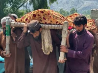 Warga Afghanistan membawa korban serangan udara Pakistan di Kunar