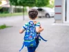 Ilustrasi anak berjalan mengenakan tas ransel ke sekolah.