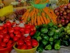 Tumpukan tomat, wortel, paprika hijau, bawang merah, dan terung Afrika di lapak pasar Rwanda