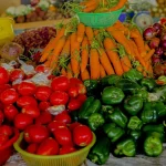 Tumpukan tomat, wortel, paprika hijau, bawang merah, dan terung Afrika di lapak pasar Rwanda