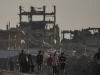 Warga Palestina di antara reruntuhan bangunan yang hancur akibat serangan udara Israel di Kota Gaza