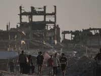 Warga Palestina di antara reruntuhan bangunan yang hancur akibat serangan udara Israel di Kota Gaza