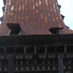 Atap menjulang dan fasad kayu berukir rumah adat Omo Nifolasara di Bawomataluo, Nias Selatan