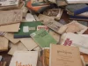 Tumpukan buku dan majalah lama berbahasa Indonesia di atas meja kayu dalam sebuah pameran arsip