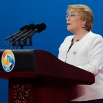 Michelle Bachelet berbicara di podium dalam sebuah forum internasional