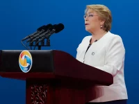 Michelle Bachelet berbicara di podium dalam sebuah forum internasional