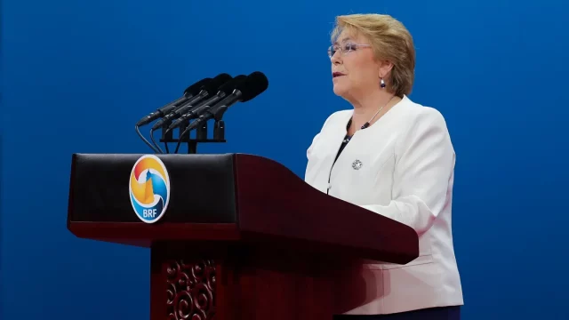 Michelle Bachelet berbicara di podium dalam sebuah forum internasional