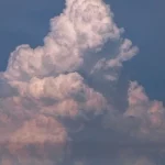 Awan kumulonimbus menjulang tinggi di langit biru
