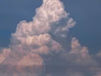 Awan kumulonimbus menjulang tinggi di langit biru