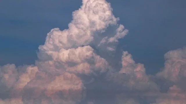 Awan kumulonimbus menjulang tinggi di langit biru