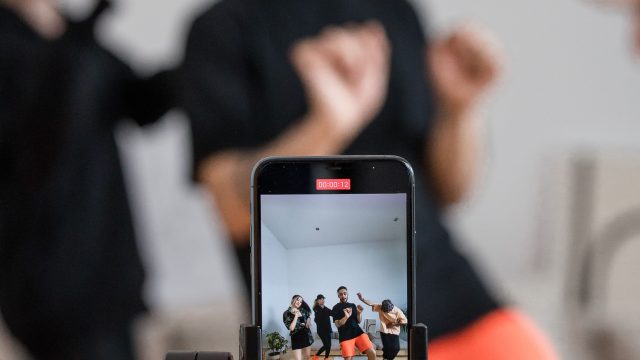 Ilustrasi telepon pintar merekam sekelompok orang yang sedang menari.