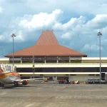 Gedung terminal Bandara Internasional Juanda dengan pesawat terparkir di apron