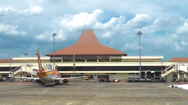 Gedung terminal Bandara Internasional Juanda dengan pesawat terparkir di apron