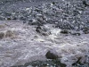 Air banjir keruh mengalir deras di antara bongkahan batu Grand Canyon