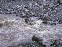 Air banjir keruh mengalir deras di antara bongkahan batu Grand Canyon