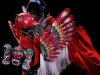 Barong Kemiren bersayap dan bermahkota merah dalam sebuah pertunjukan di panggung gelap