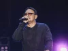 Bebi Romeo menyanyi di atas panggung sambil menggenggam mikrofon.