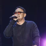 Bebi Romeo menyanyi di atas panggung sambil menggenggam mikrofon.