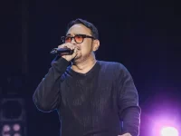 Bebi Romeo menyanyi di atas panggung sambil menggenggam mikrofon.