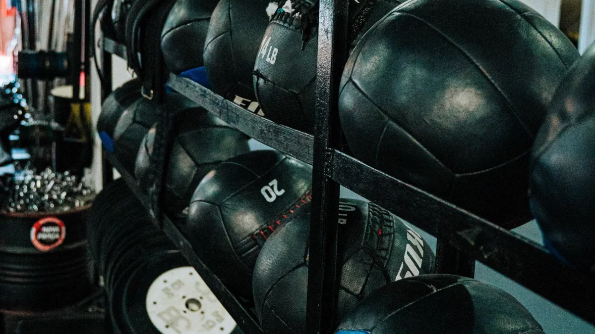 Bola medisin hitam tersusun berjajar pada rak besi di ruang latihan