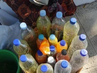 Sekeranjang botol plastik berisi jamu berwarna kuning, jingga, dan cokelat