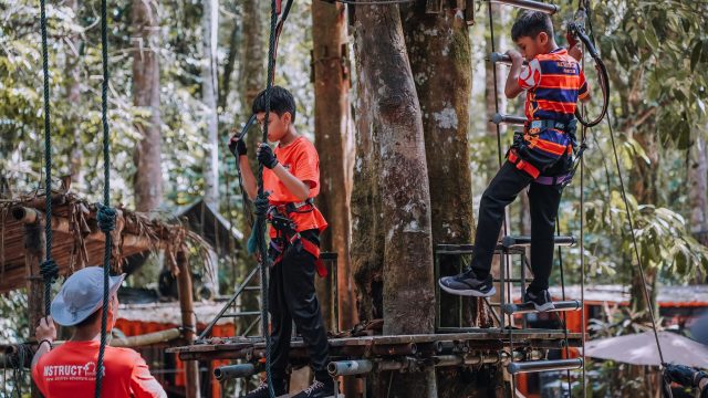 Ilustrasi anak-anak menyusuri wahana tali di sebuah taman petualangan.