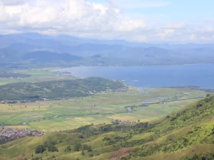 Hamparan sawah, permukiman, dan Danau Kerinci dilihat dari lereng Bukit Kayangan