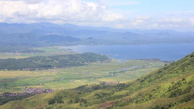 Hamparan sawah, permukiman, dan Danau Kerinci dilihat dari lereng Bukit Kayangan