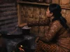 Perempuan memasak dengan tungku kayu di sebuah dapur tradisional