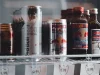 Kaleng dan botol minuman energi berjajar di rak lemari pendingin toko berlabel harga
