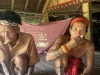 Dua sikerei Mentawai lanjut usia bertato duduk di lantai rumah uma