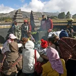 Ilustrasi warga berkumpul di sekitar sesaji dan asap dupa pada upacara Yadnya Kasada di kawasan Gunung Bromo