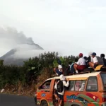 Warga menyaksikan erupsi Gunung Sinabung dari atas angkutan umum di Kabupaten Karo, Sumatera Utara