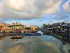 Rumah-rumah panggung Suku Bajau berjajar di atas air dengan langit berawan